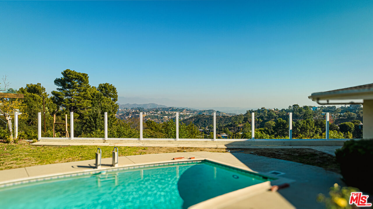 1950 Carla Ridge Beverly Hills, CA 90210 - Photo 24 of 29 a view of swimming pool with lawn chairs and large trees
