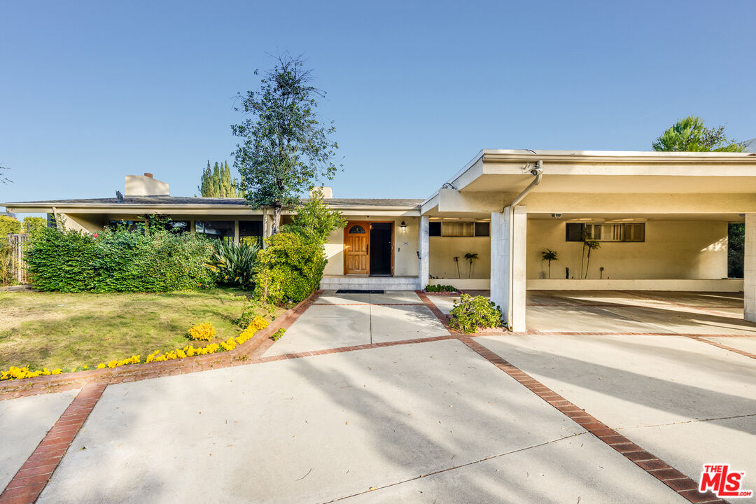 1950 Carla Ridge Beverly Hills, CA 90210 - Photo 4 of 29 a view of yellow house with swimming pool in front of it