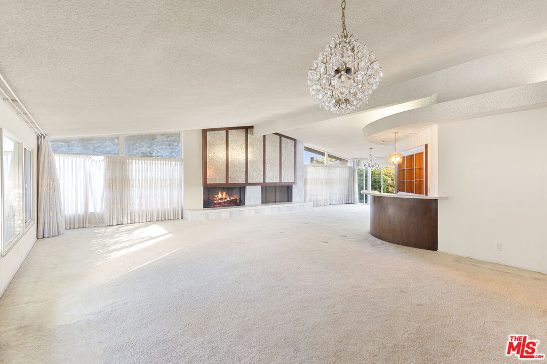 1950 Carla Ridge Beverly Hills, CA 90210 - Photo 9 of 29 a view of a big room with windows and chandelier