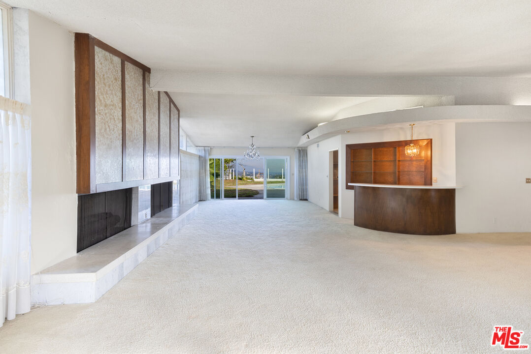 1950 Carla Ridge Beverly Hills, CA 90210 - Photo 10 of 29 a large bedroom with a large bed and a flat screen tv