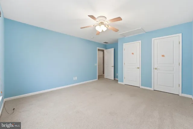 a view of an empty room with a chandelier fan