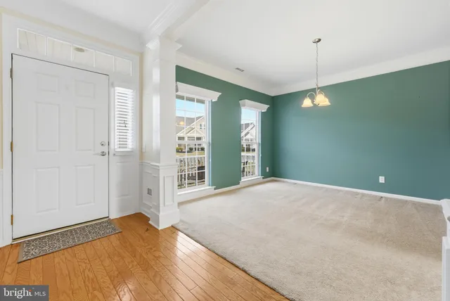 a view of a livingroom with a chandelier fan and windows