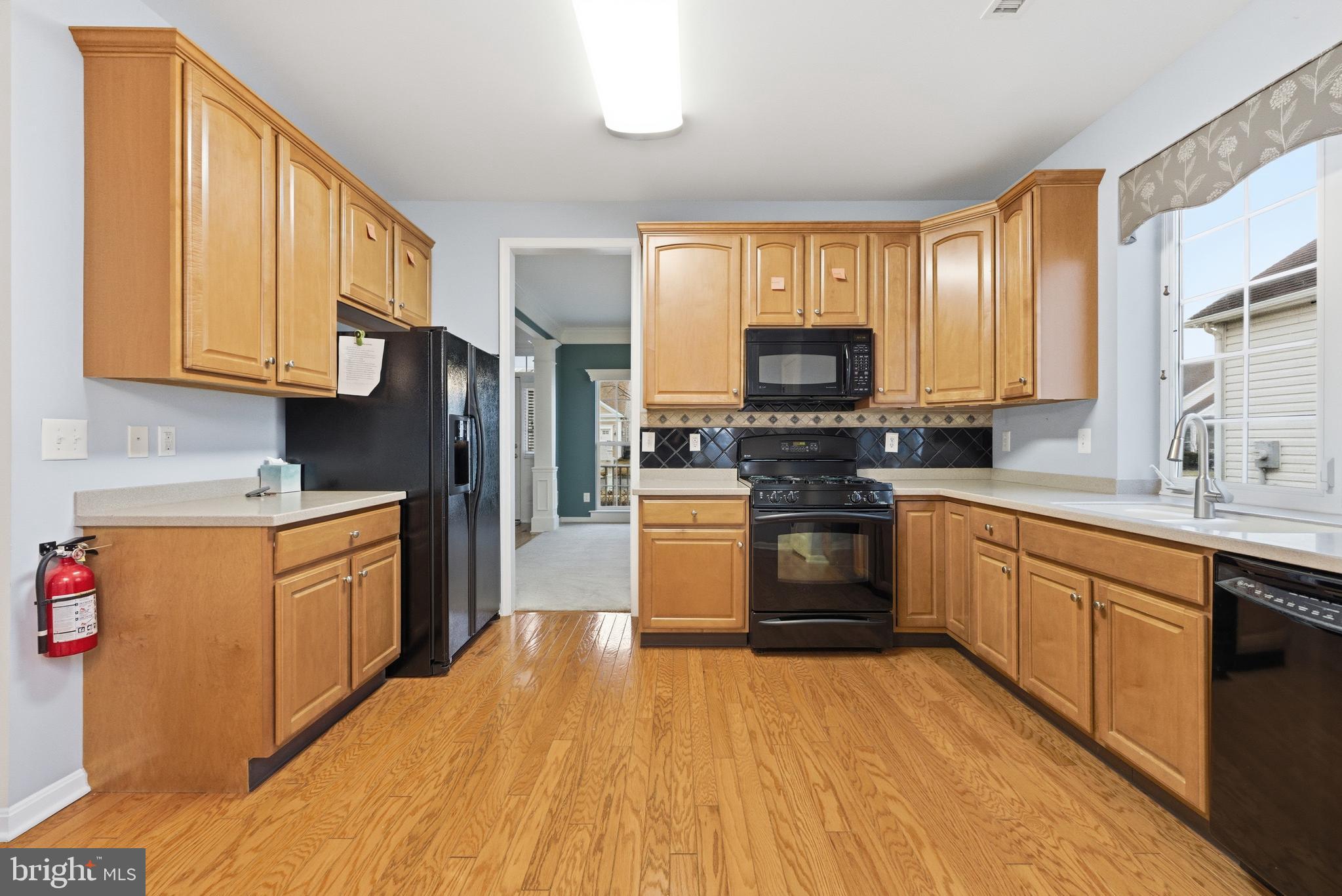 67 Pennington Court Delanco, NJ 08075 - Photo 8 of 35 a kitchen with granite countertop a stove top oven a sink dishwasher and a refrigerator with wooden floor