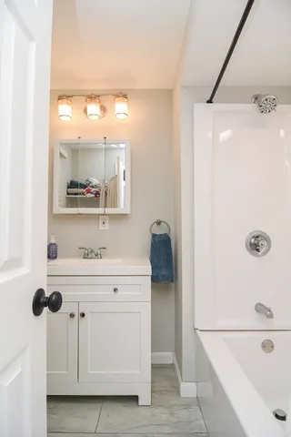a bathroom with a sink a toilet a mirror and shower