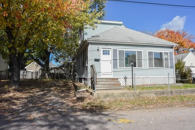 a front view of a house with a tree
