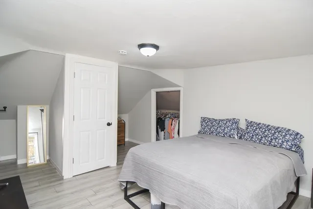 a bedroom with a bed and wooden floor