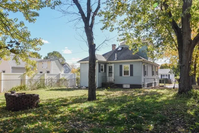 a front view of a house with a yard and large tree