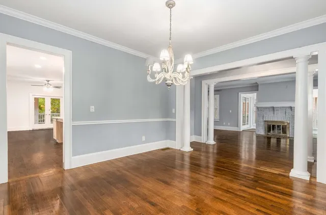 an empty room with wooden floor and fireplace