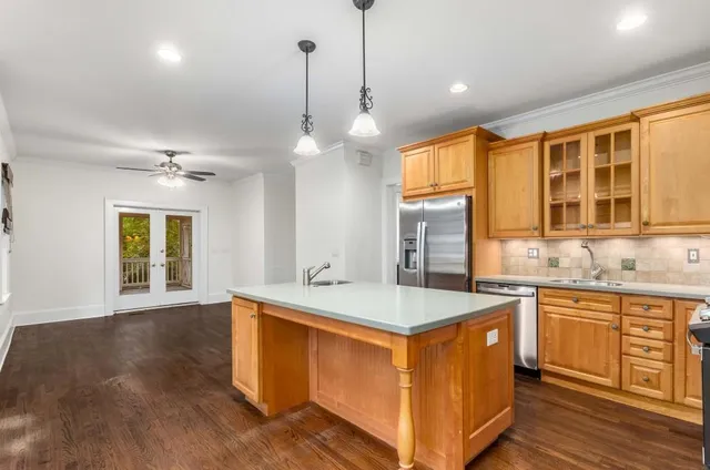 a kitchen with a stove a sink a center island and windows