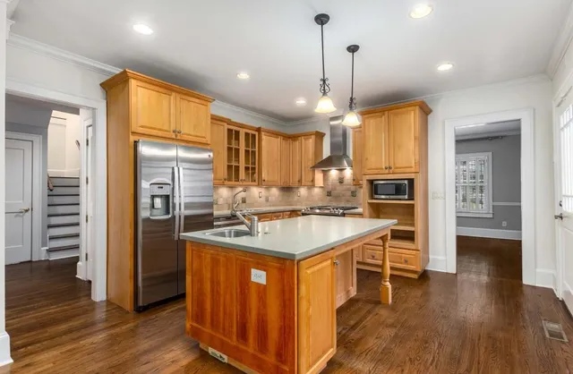 a kitchen with kitchen island a stove a refrigerator a sink and wooden floor