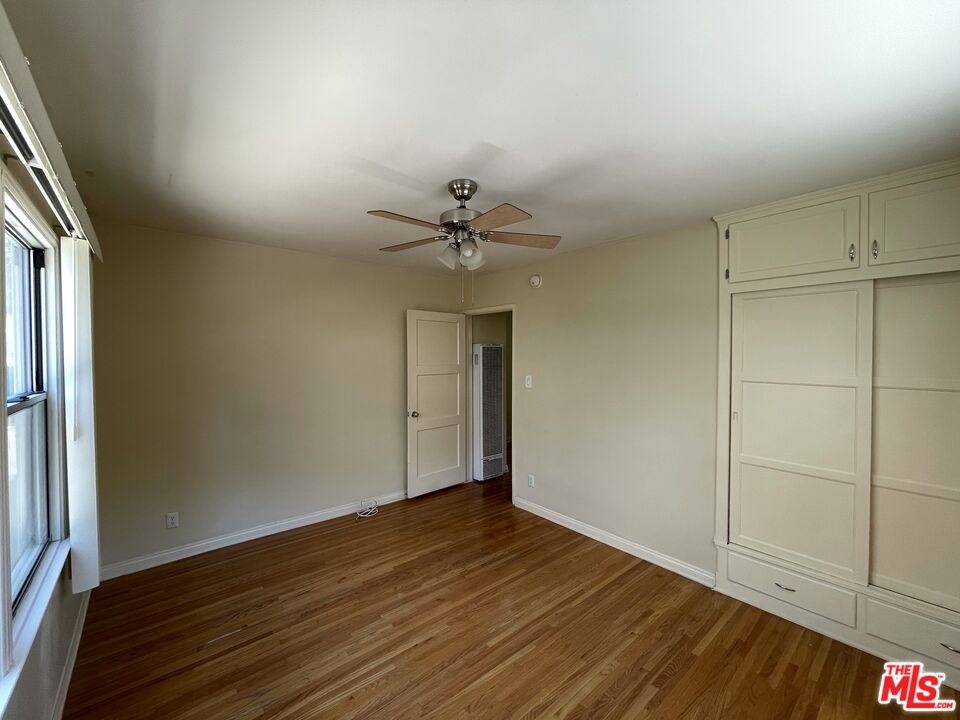 14940 Dickens Street, Unit 1 Sherman Oaks, CA 91403 - Photo 12 of 16 a view of a room with wooden floor and a ceiling fan
