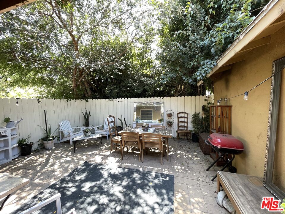 14940 Dickens Street, Unit 1 Sherman Oaks, CA 91403 - Photo 13 of 16 a view of a patio with table and chairs with wooden fence and plants
