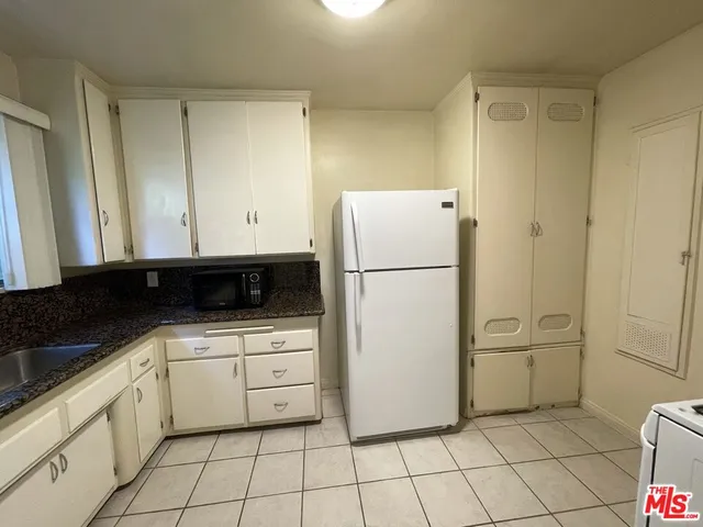 a kitchen with white cabinets and white appliances
