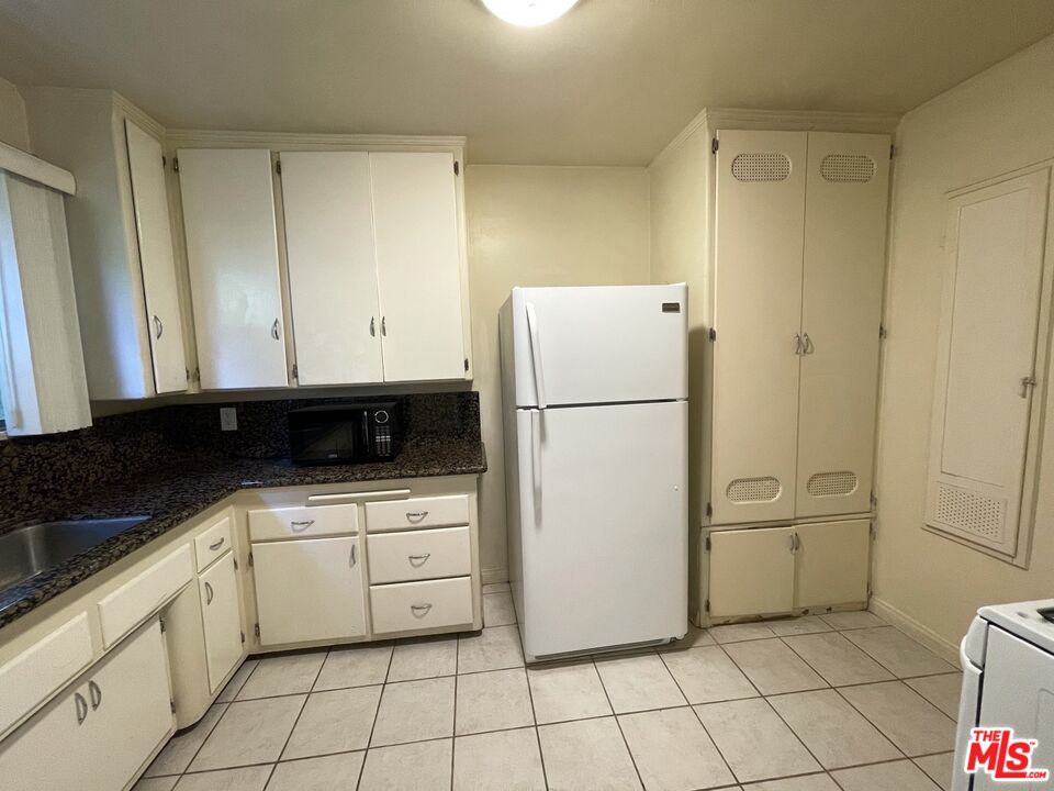 14940 Dickens Street, Unit 1 Sherman Oaks, CA 91403 - Photo 9 of 16 a kitchen with white cabinets and white appliances