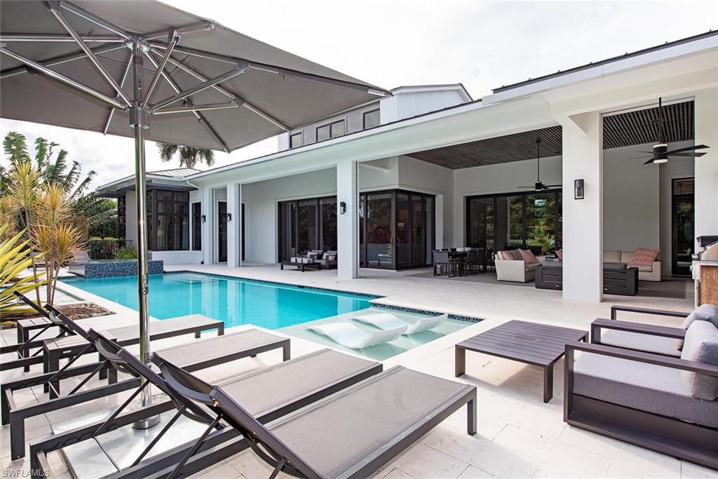 1300 Nautilus Road Naples, FL 34102 - Photo 1 of 21 a view of a patio with table and chairs under an umbrella