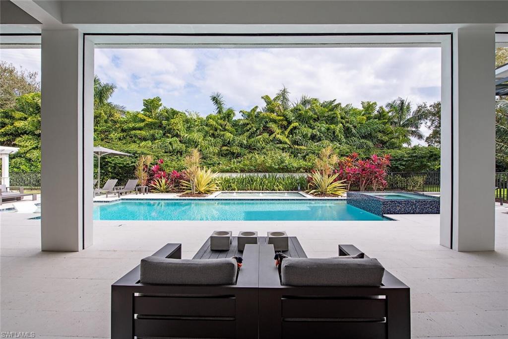 1300 Nautilus Road Naples, FL 34102 - Photo 2 of 21 a view of a chairs and table in a back yard