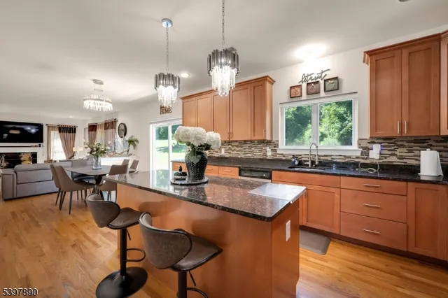 a kitchen with stainless steel appliances granite countertop wooden cabinets a dining table and chairs