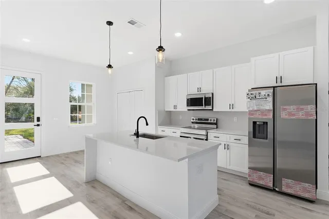 a kitchen with stainless steel appliances granite countertop a refrigerator a sink a stove a microwave and island