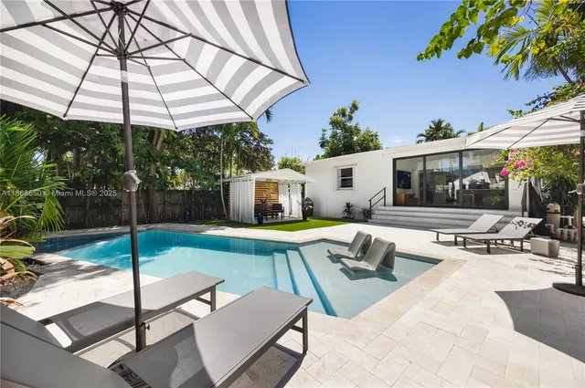 a view of a patio with a table and chairs under an umbrella