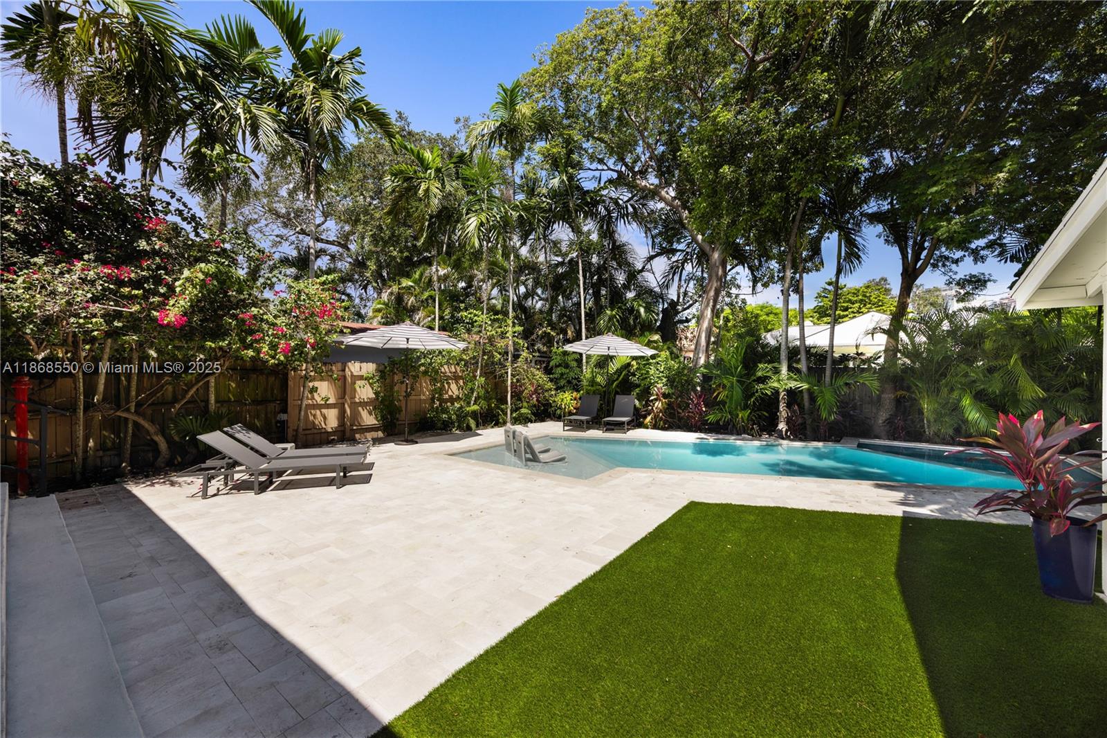 141 Southwest 23rd Road Miami, FL 33129 - Photo 30 of 32 a view of a patio with table and chairs a fire pit and large trees