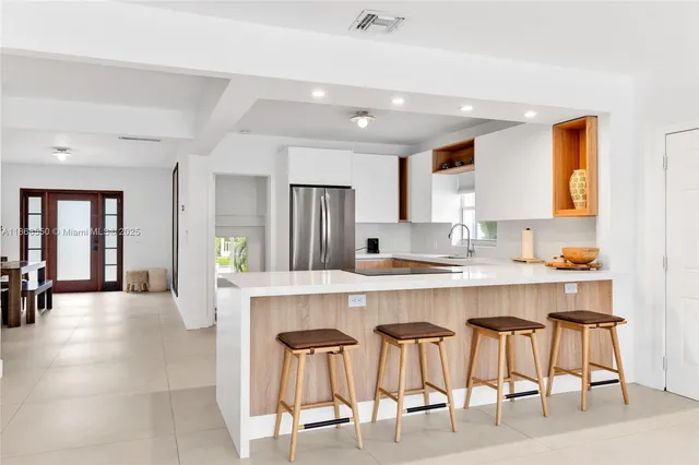 a large white kitchen with a table and chairs