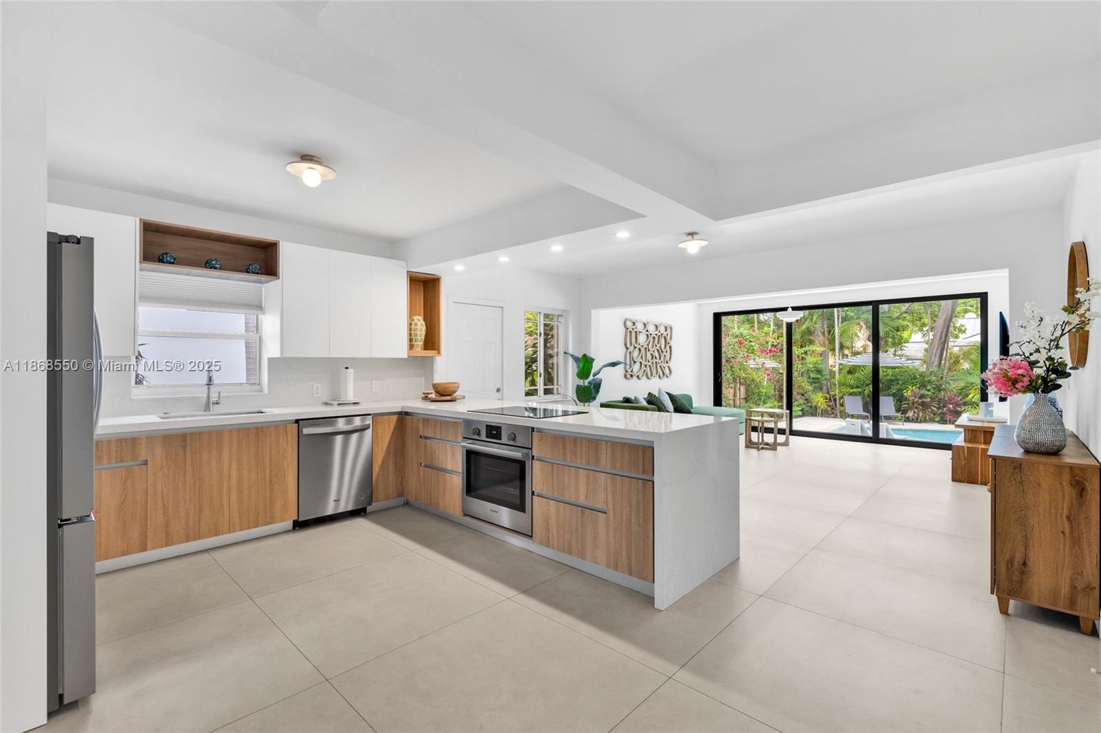 141 Southwest 23rd Road Miami, FL 33129 - Photo 9 of 32 a large room with kitchen island a large window a sink and stainless steel appliances