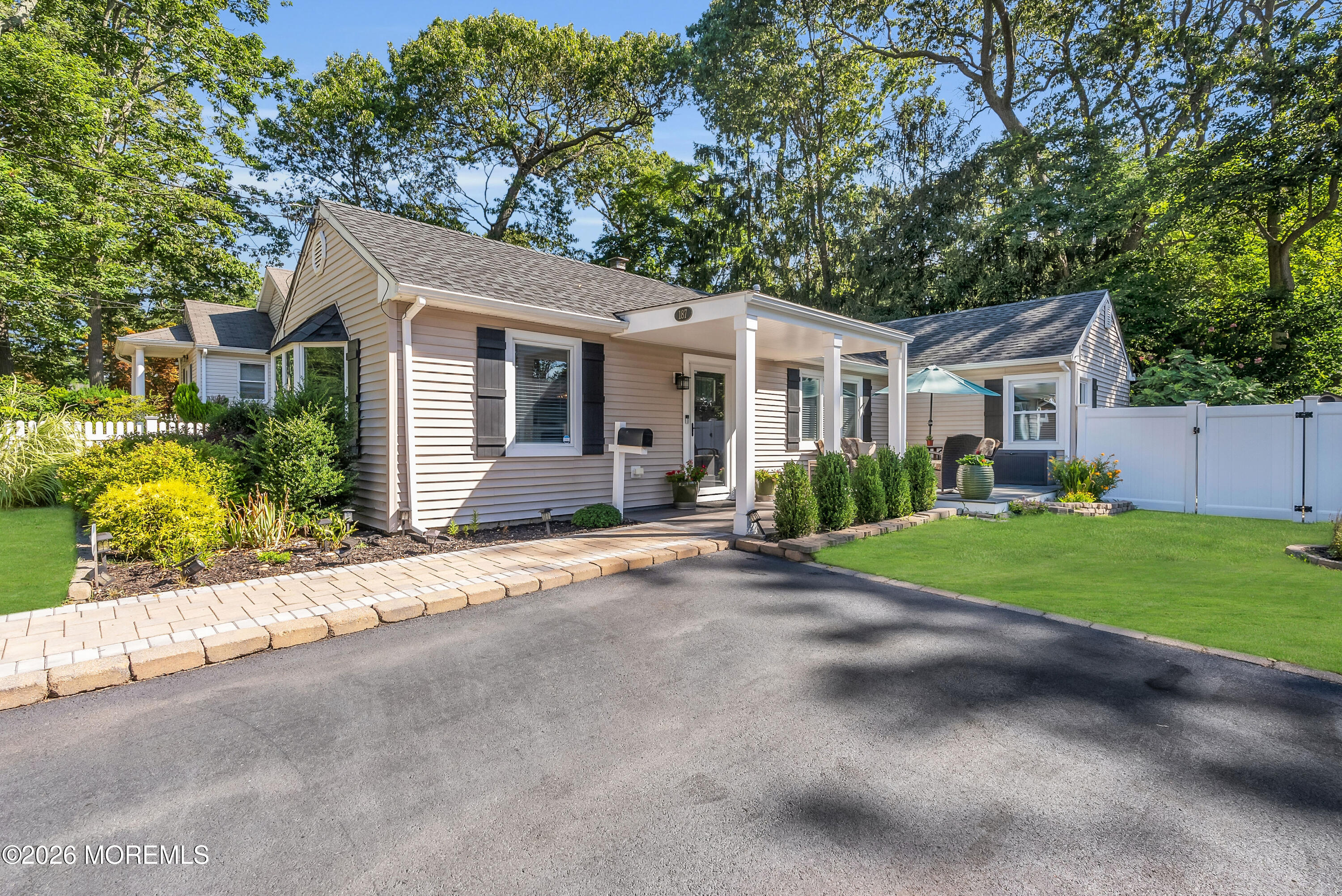 a view of a house with a yard and large tree