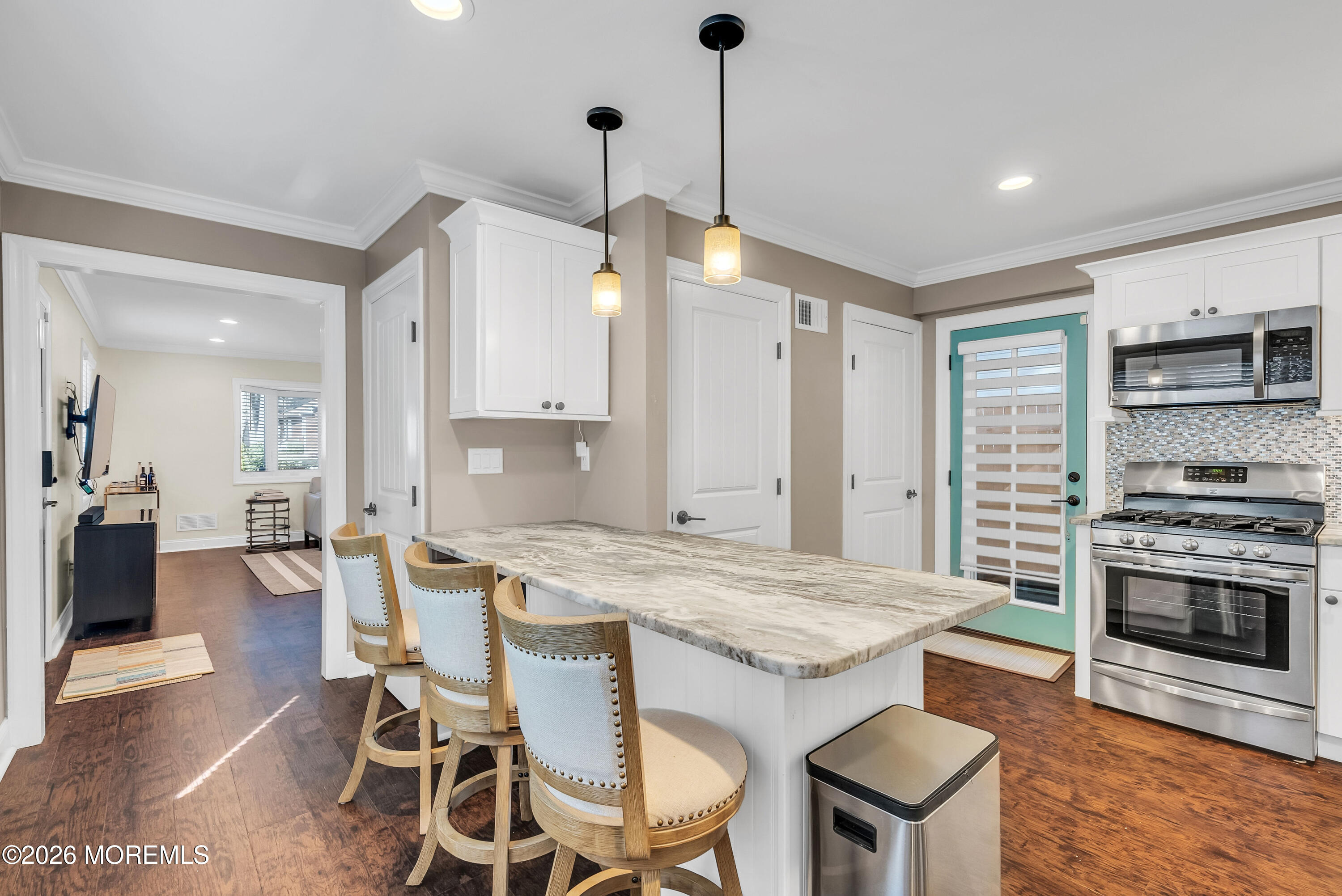 187 Pinecrest Road Oakhurst, NJ 07755 - Photo 12 of 26 a kitchen with a stove a kitchen island a table and chairs in it