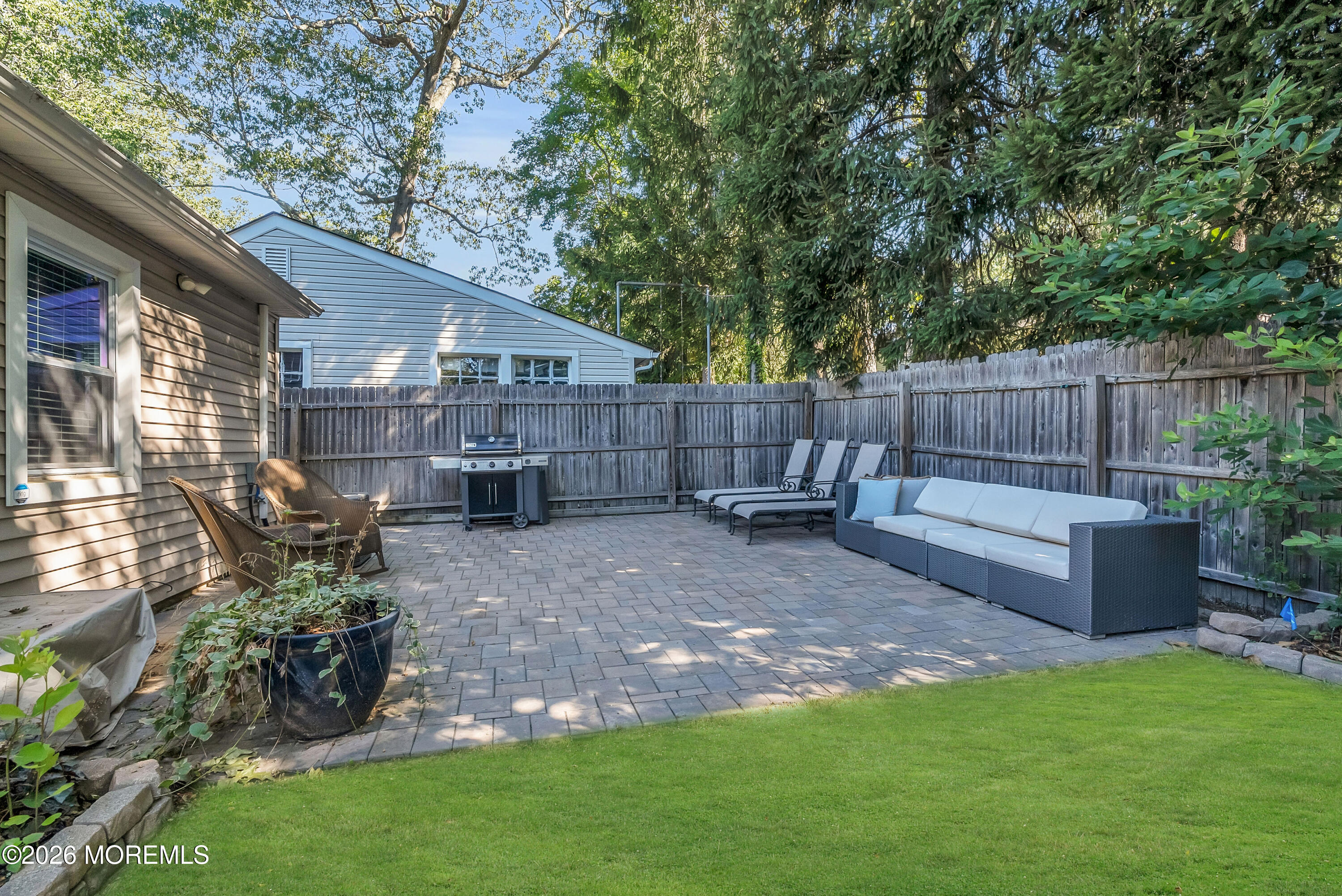 187 Pinecrest Road Oakhurst, NJ 07755 - Photo 23 of 26 a view of backyard with table and chairs potted plants and wooden fence