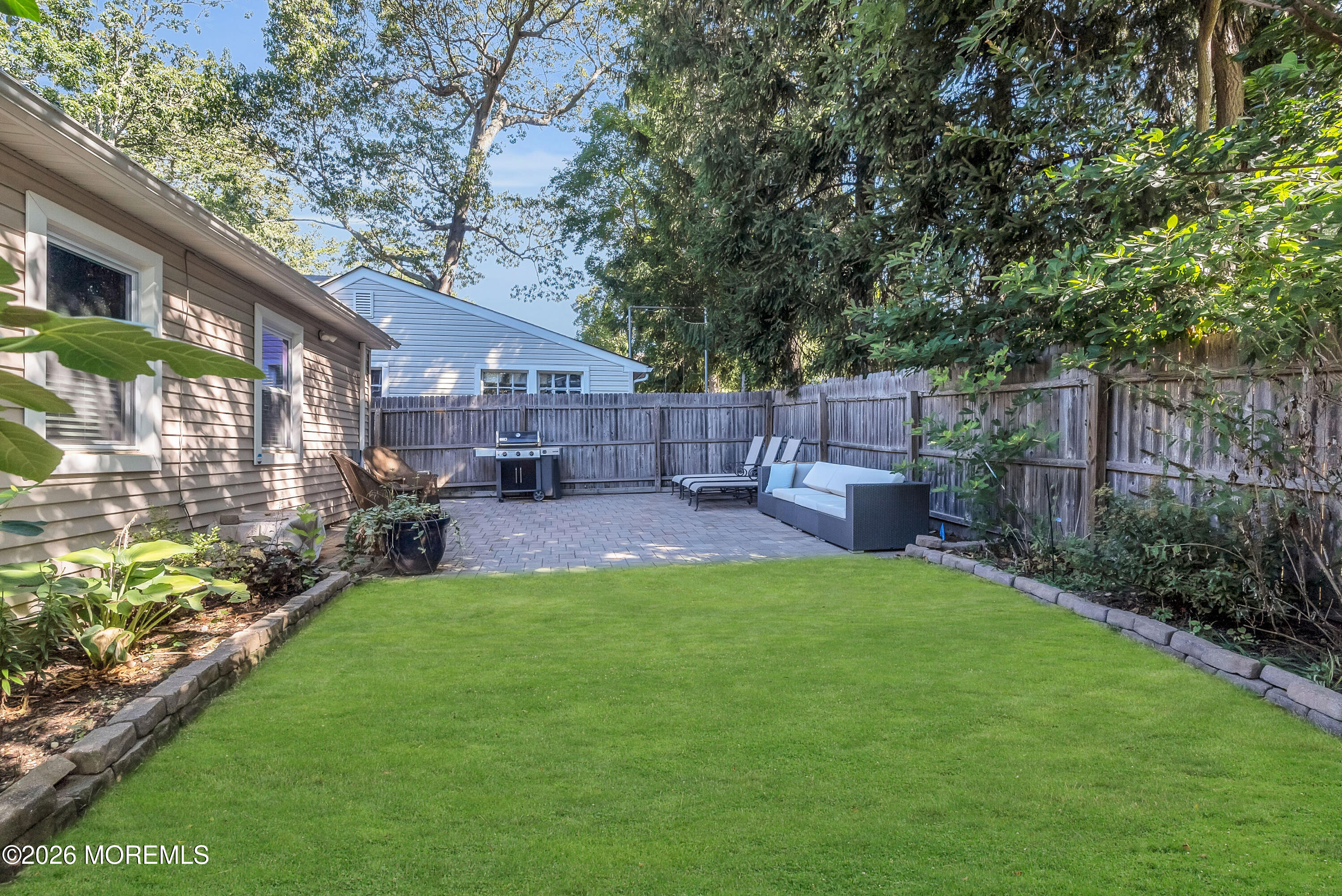 187 Pinecrest Road Oakhurst, NJ 07755 - Photo 24 of 26 a view of a backyard with table and chairs with a fire pit and a large tree