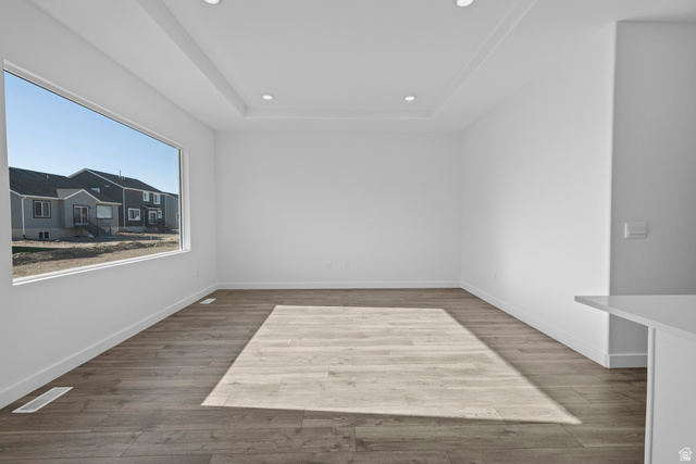 2823 North 710 West, Unit 16 Logan, UT 84321 - Photo 12 of 22 Unfurnished room with light wood-style flooring, recessed lighting, and a tray ceiling