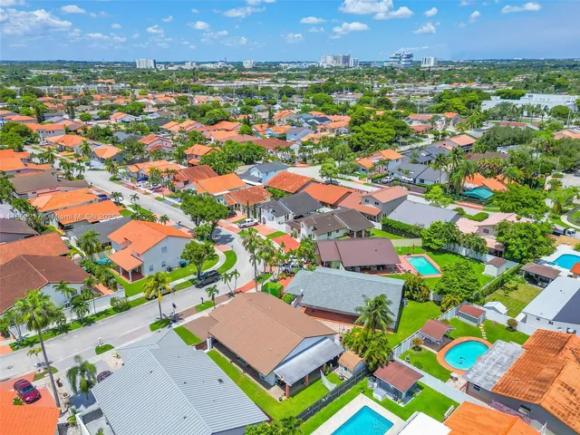 an aerial view of residential houses with outdoor space and street view