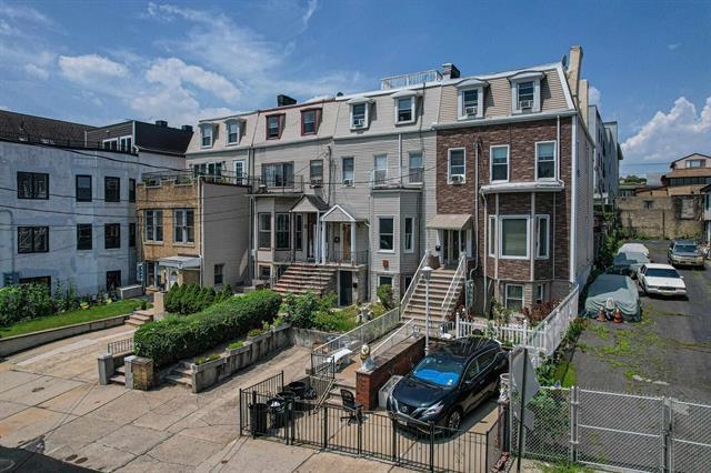 298 Paterson Plank Road Jersey City, NJ 07307 - Photo 7 of 13 a front view of a house with a garden and sitting area