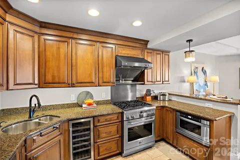 a kitchen with stainless steel appliances granite countertop a sink stove and cabinets