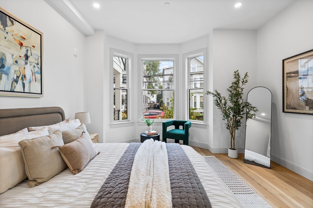 54 Springfield Street, Unit 1 Somerville, MA 02143 - Photo 11 of 38 a bedroom with a large bed and a chandelier