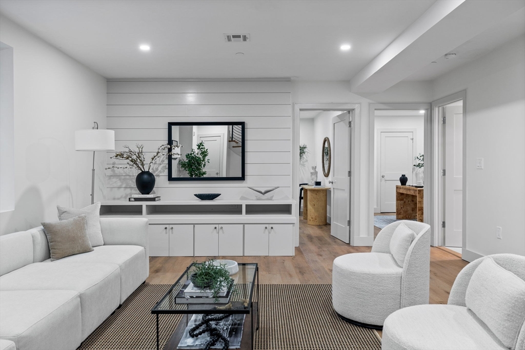 54 Springfield Street, Unit 1 Somerville, MA 02143 - Photo 20 of 38 a living room with furniture kitchen view and a wooden floor