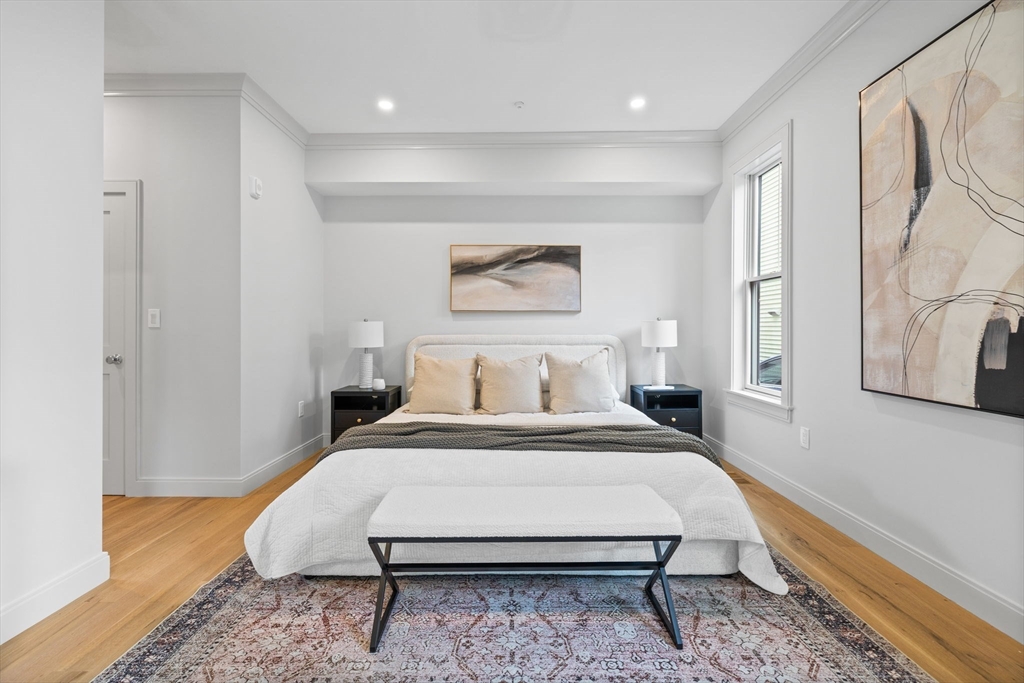 54 Springfield Street, Unit 1 Somerville, MA 02143 - Photo 33 of 38 a bedroom with a bed and wooden floor