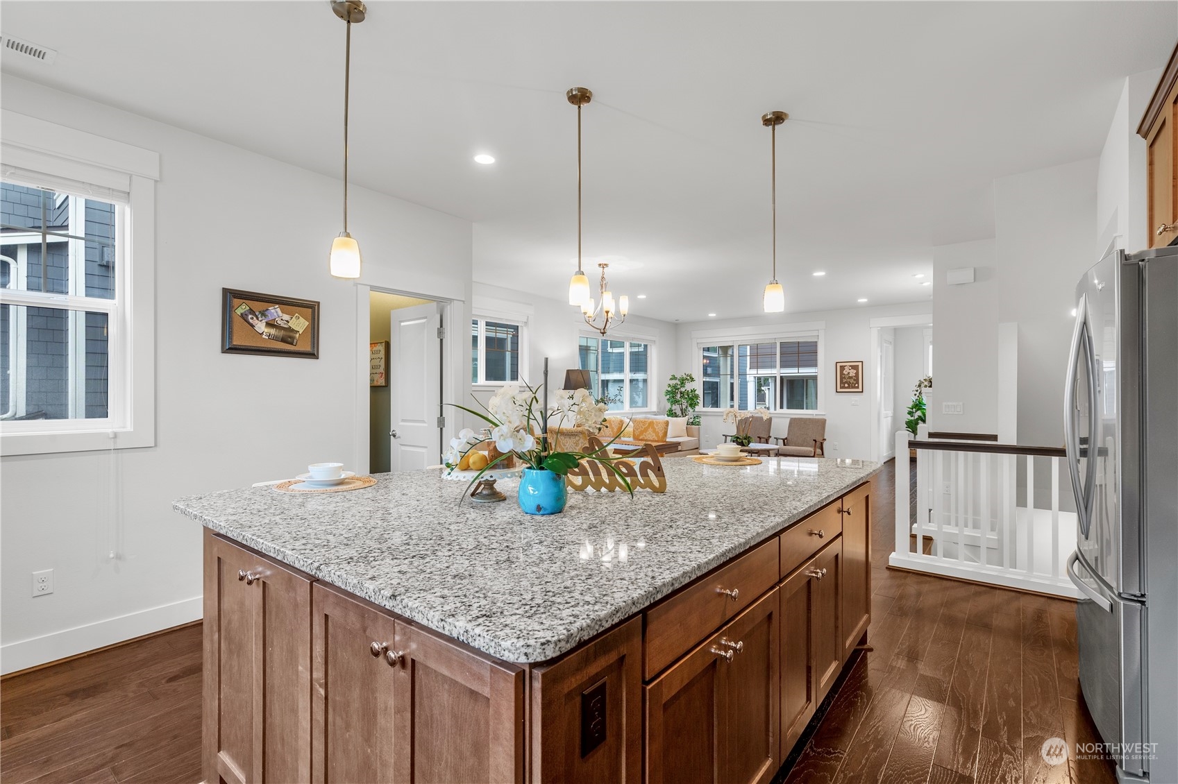 4524 186th Place Southeast, Unit A Bothell, WA 98012 - Photo 8 of 30 a kitchen with granite countertop kitchen island stainless steel appliances a dining table a sink and a wooden floor