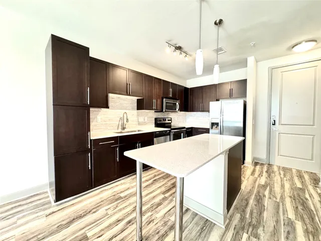 a kitchen with kitchen island a refrigerator stove microwave and cabinets