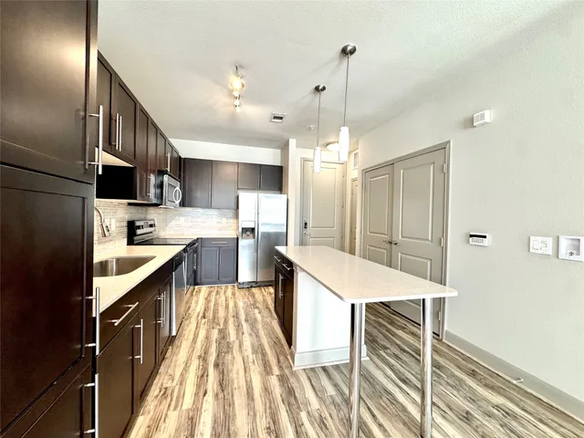 a large kitchen with kitchen island a sink a counter space and stainless steel appliances