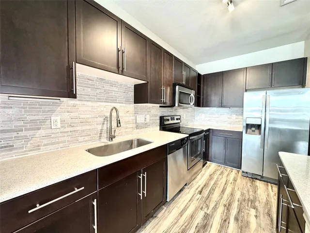 a kitchen with kitchen island granite countertop wooden cabinets and stainless steel appliances