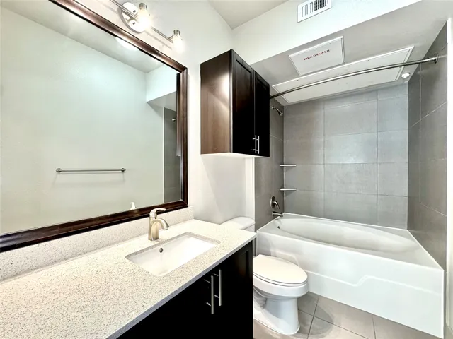a bathroom with a granite countertop sink toilet and shower