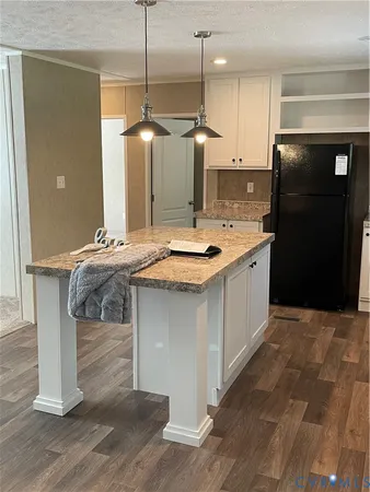 a kitchen with kitchen island granite countertop a sink a counter top space and stainless steel appliances