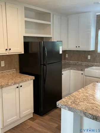 a kitchen with a refrigerator sink and cabinets
