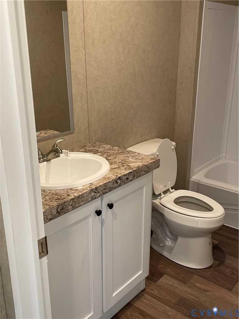 24911 Rainey Creek Road McKenney, VA 23872 - Photo 17 of 20 a bathroom with a granite countertop toilet a sink and a mirror