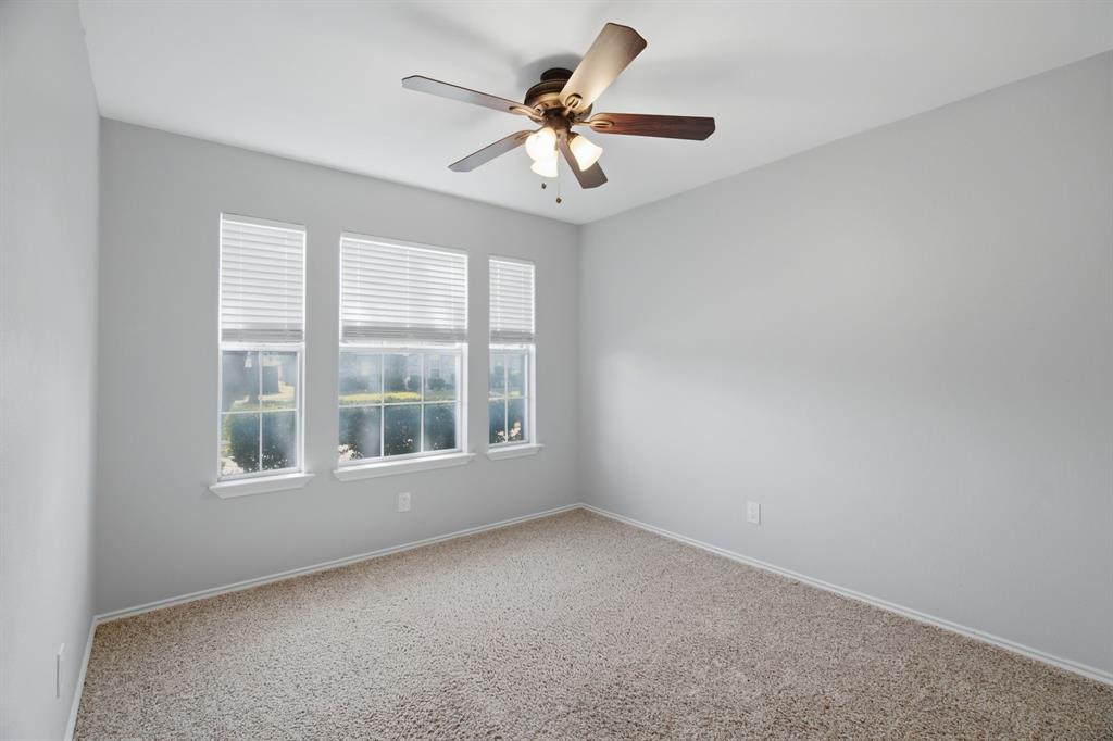 2074 Briarcliff Road Lewisville, TX 75067 - Photo 22 of 40 Room featuring three windows with blinds, light-colored walls, and neutral carpeting