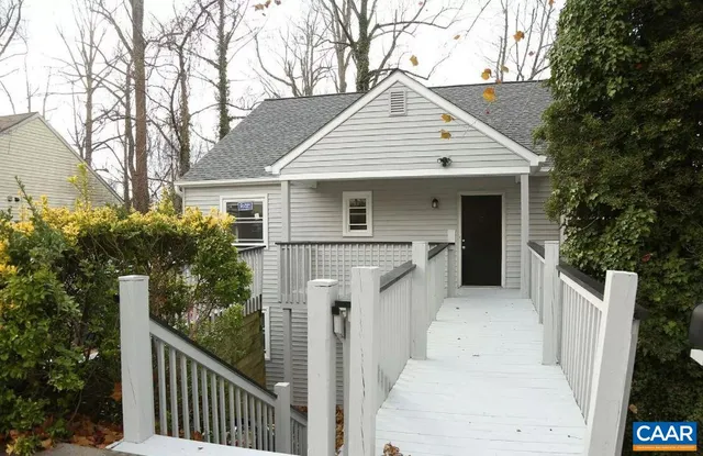 a view of house with a yard and potted plants