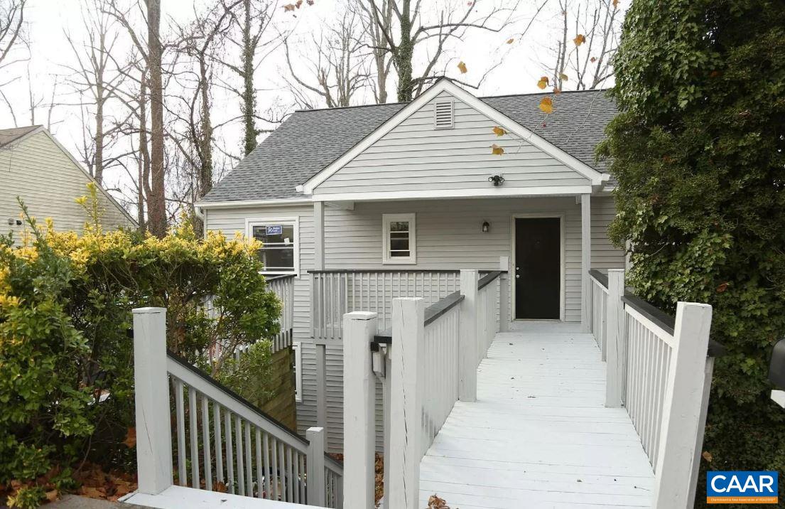 a view of house with a yard and potted plants