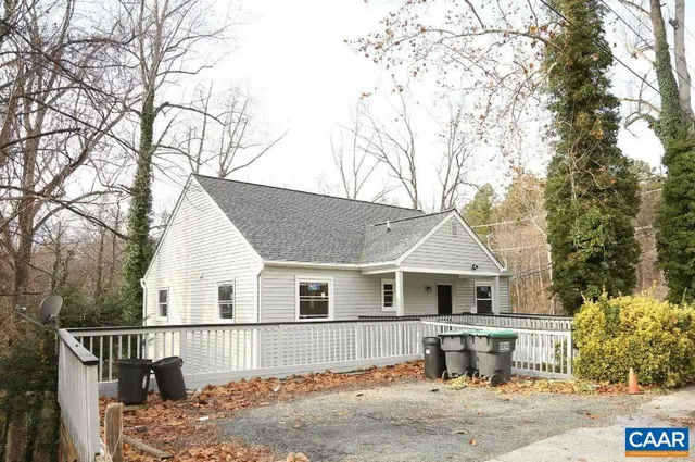 a view of a white house with a large trees