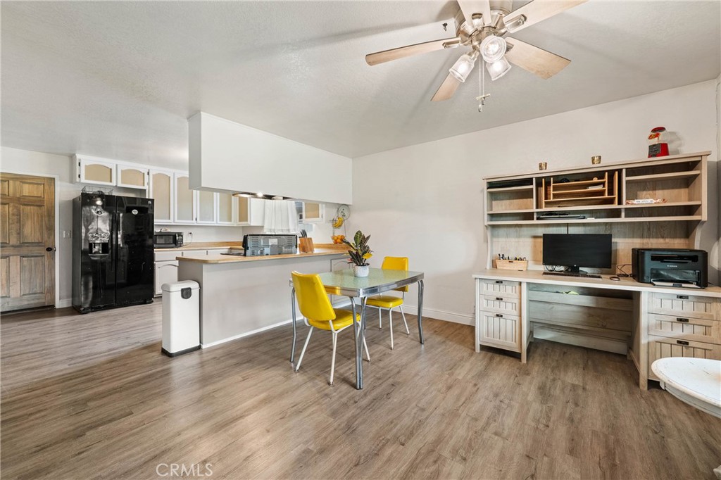 19425 Old Creek Road Hidden Valley Lake, CA 95467 - Photo 12 of 42 a kitchen with stainless steel appliances a stove a refrigerator a kitchen island a dining table and chairs with wooden floor